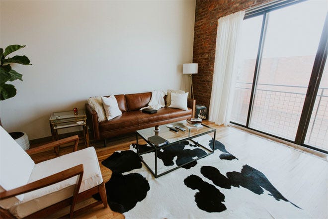 Cow skin rug and other nice soft furnishings in a living room