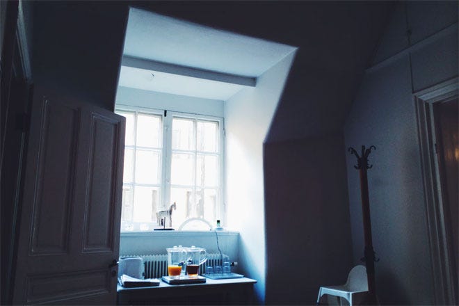 Two jugs of fruit juice in front of a nice bright window close to a radiator - Hygge | Unsplash.com
