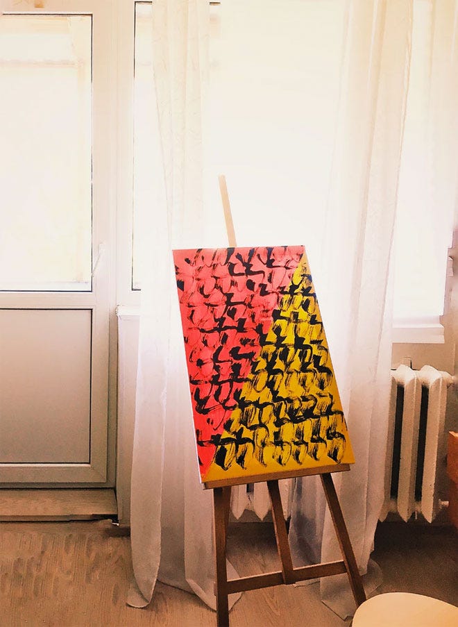 A modern art painting on an easel in front of a white curtain and chunky radiator - Hygge | Unsplash.com