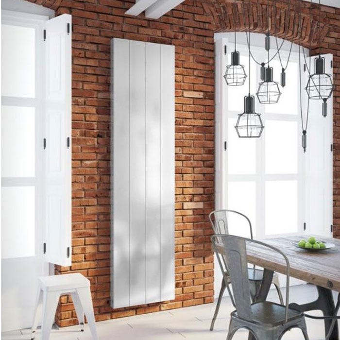 DQ VELA DESIGNER ELECTRIC RADIATOR in a room set against a brick wall.