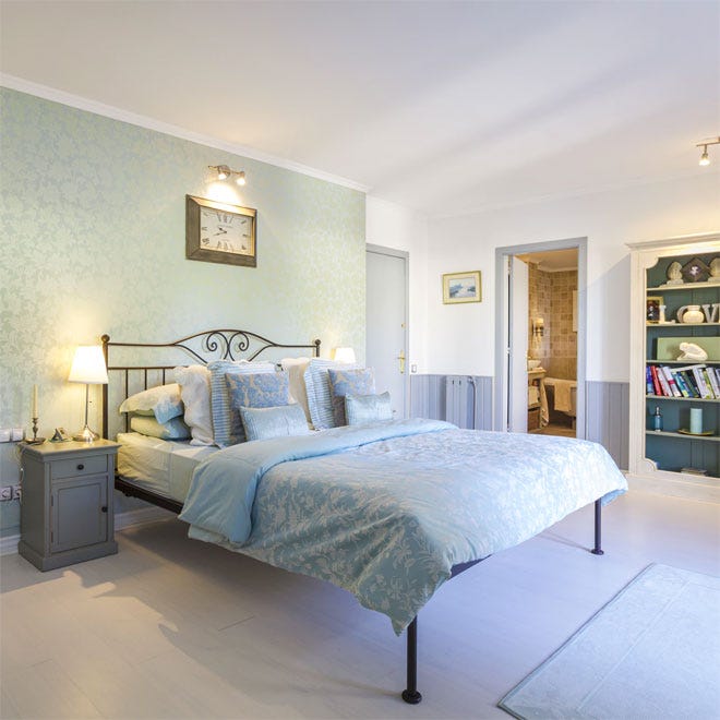 A beautiful bedroom with a feature wall behind the bed