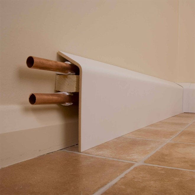 Copper radiator pipes concealed by skirting board