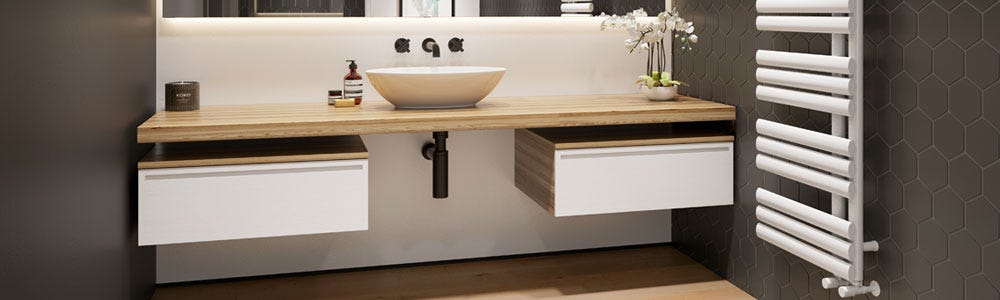 A white heated towel rail on the wall in a modern bathroom