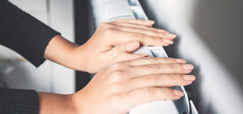 Some hands placed on a white radiator