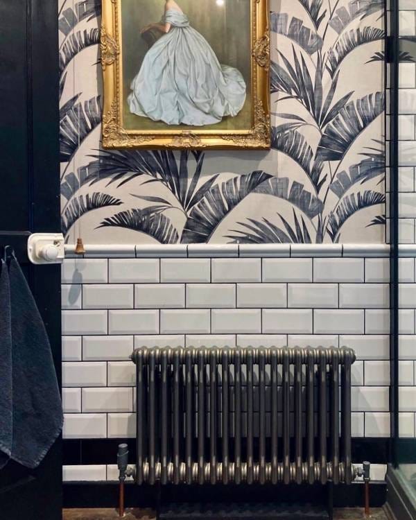 A horizontal Nordic Oslo radiator in a stylish bathroom, finished in raw metal.