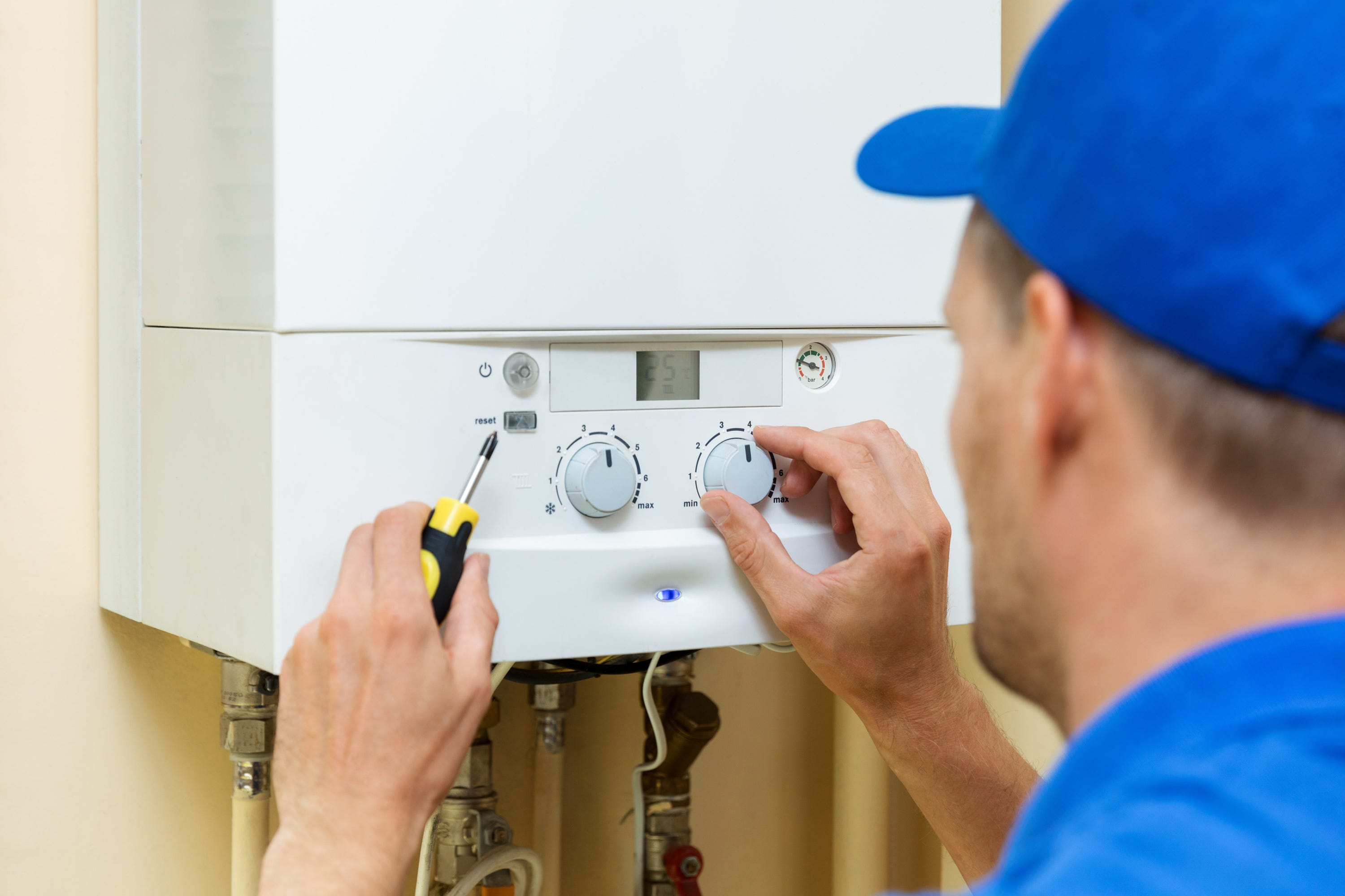 A gas-fired boiler being maintained by a heating engineer