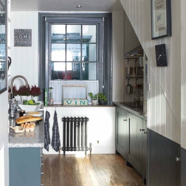 A Paladin Pimlico cast iron radiator in a small, traditional kitchen