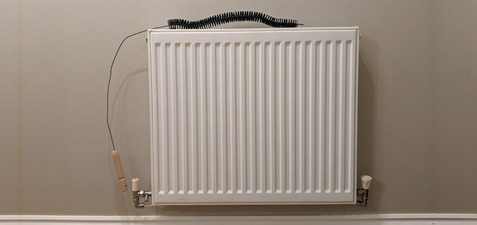 A long-handled radiator brush for cleaning convector fins and radiators with top grills.