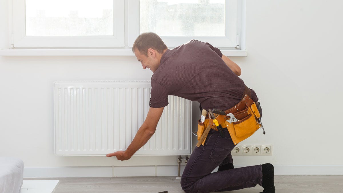 A plumber removing a radiator