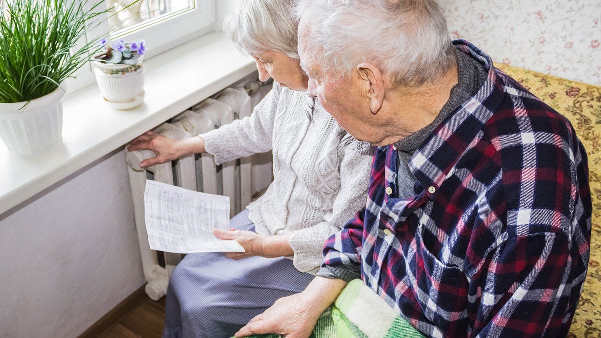 An old couple looking at the intructions for their radiator