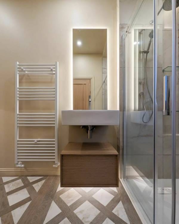 A white Reina Capo towel radiator with a ladder stying