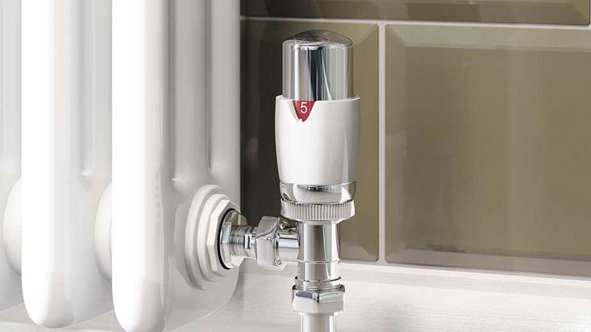 A white thernostatic radiator valve connected to a column radiator